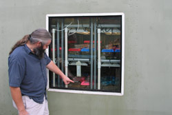 It is possible to construct windows for the containers, usually for visitors to see inside without disturbing staff or violating quarantine. Here, visitors on a threatened species tour at the ARC admire the "compactus" design of the shelves visible throug Copyright Amphibian Research Centre. Photograph by Gerry Marantelli.